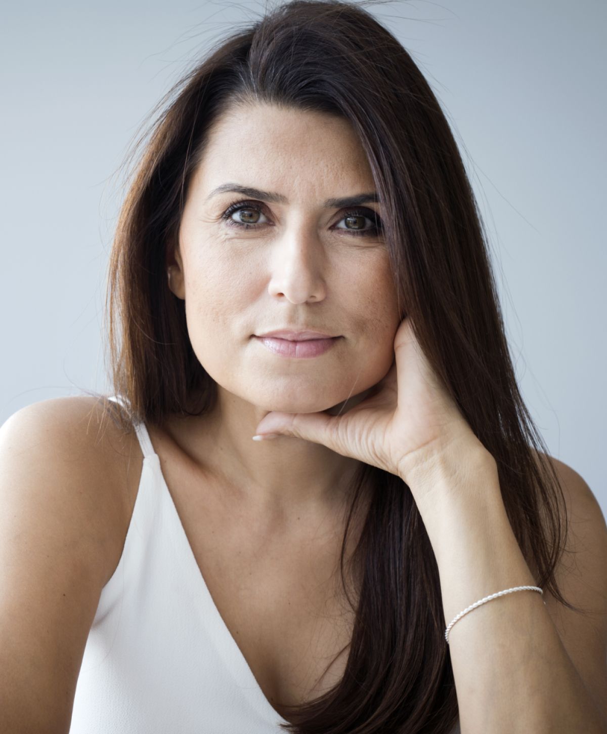 pdo thread lift patient model in a white top resting her chin on her hand