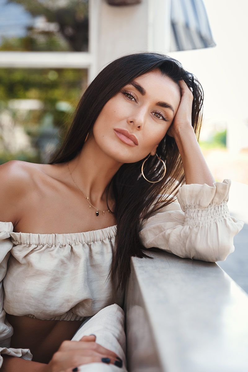 laser skin rejuvenation with long hair posing thoughtfully outdoors