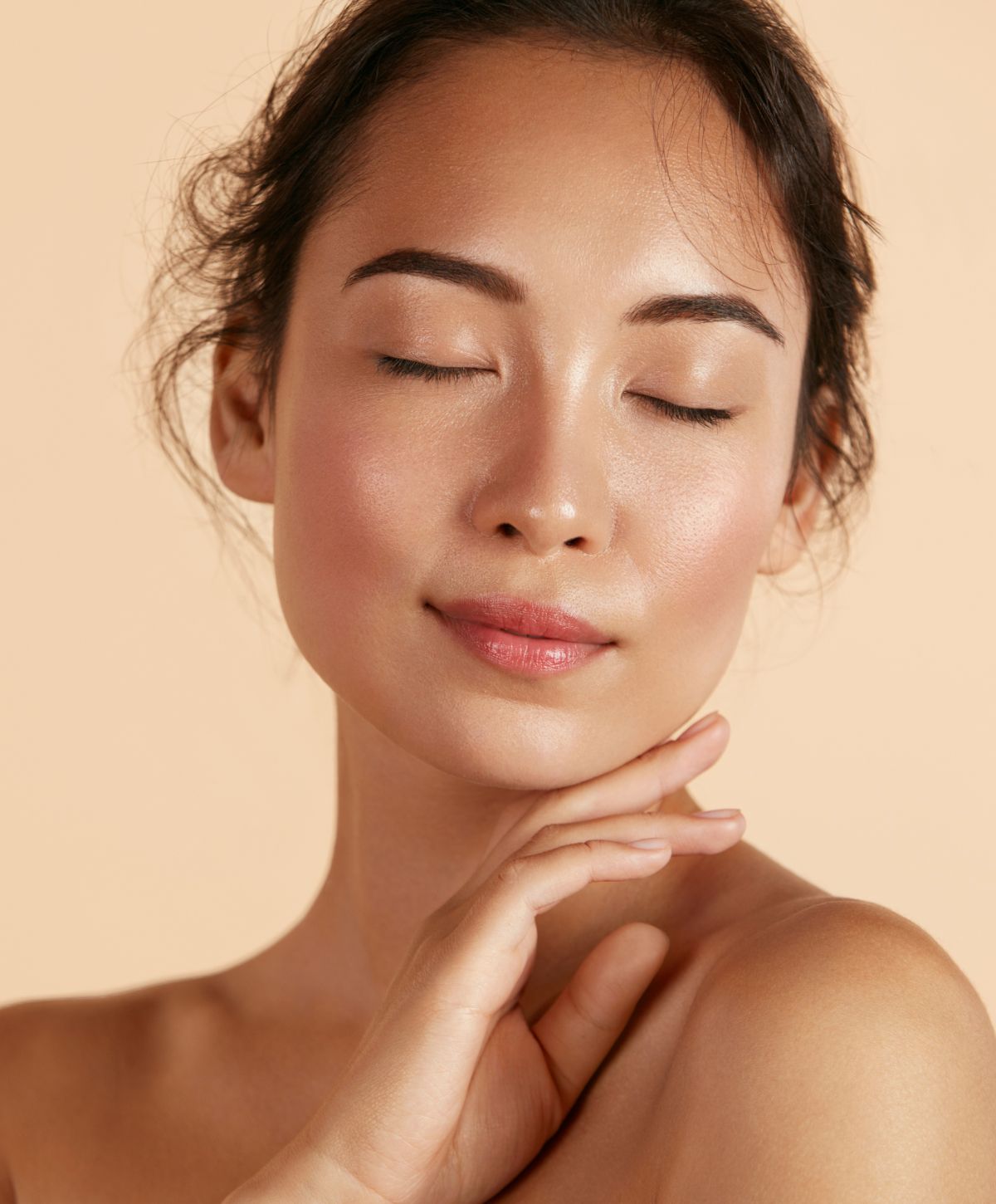 hydrafacial patient model touching her skin with her eyes closed