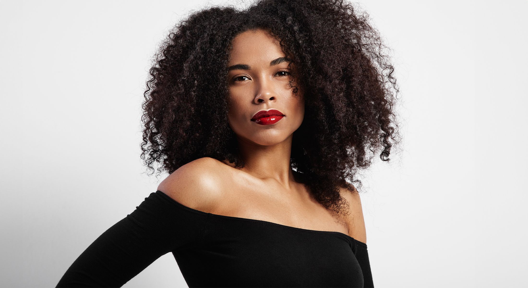 Woman with curly hair and red lipstick.